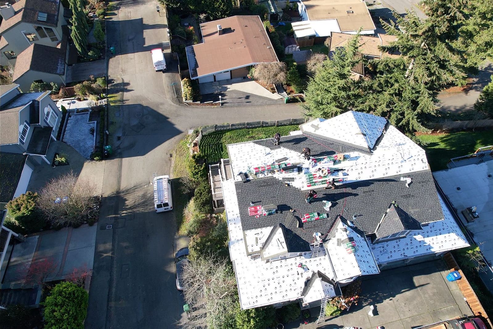 Crew installing new shingles during a roofing project